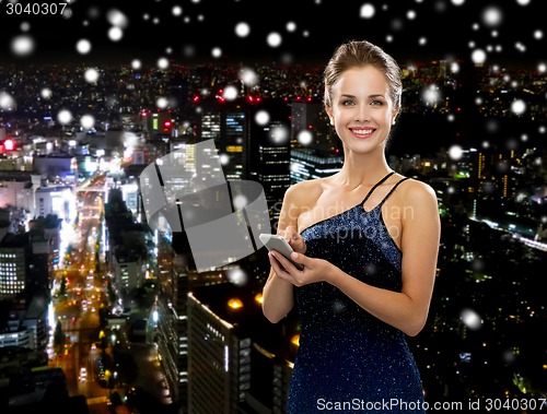Image of smiling woman in evening dress with smartphone