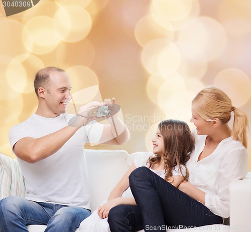 Image of happy family with camera at home
