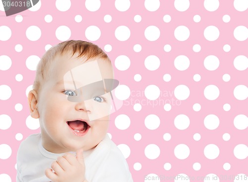 Image of smiling baby girl face over pink polka dots