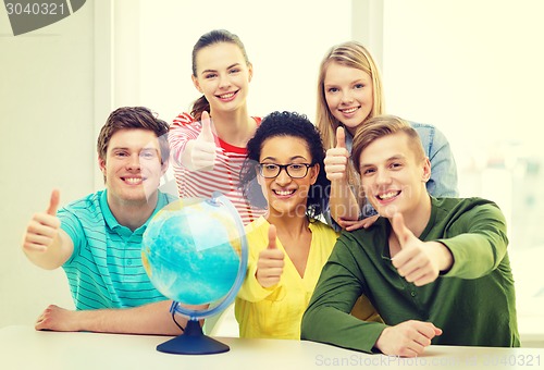 Image of five smiling student with earth globe at school