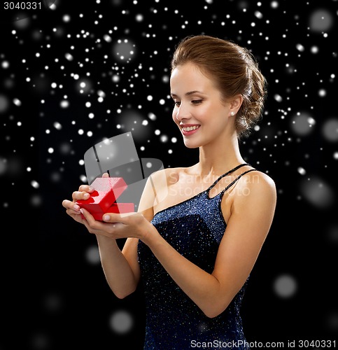 Image of smiling woman holding red gift box