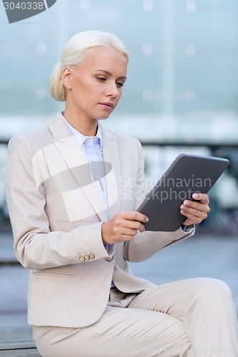 Image of businesswoman working with tablet pc outdoors