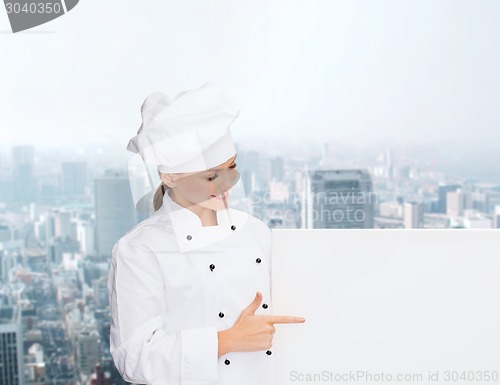 Image of smiling female chef with white blank board