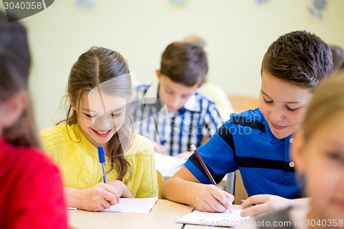 Image of group of school kids writing test in classroom