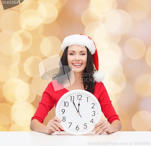 Image of smiling woman in santa helper hat with clock