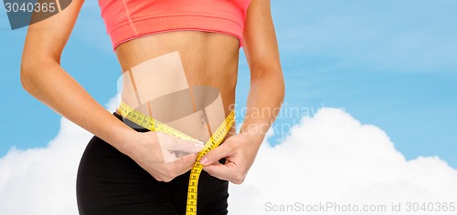 Image of close up of female hands measuring waist