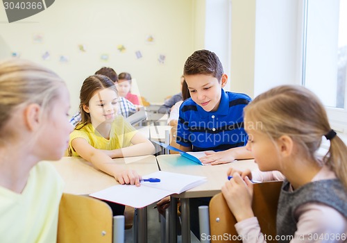 Image of group of school kids writing test in classroom