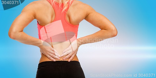 Image of close up of sporty woman touching her back