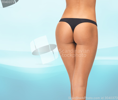 Image of close up of female legs in black bikini panties