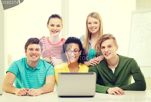 Image of smiling students with laptop at school