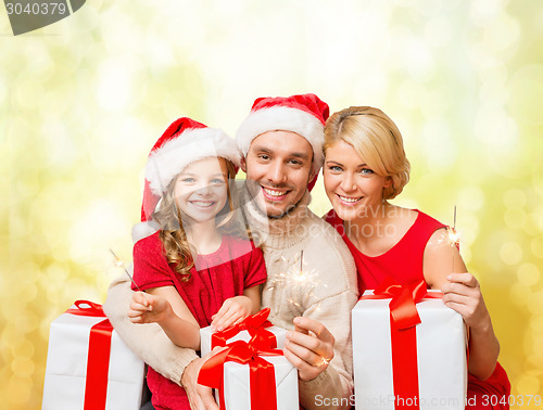 Image of smiling family holding gift boxes and sparkles