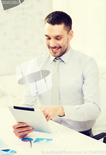 Image of businessman with tablet pc and files in office