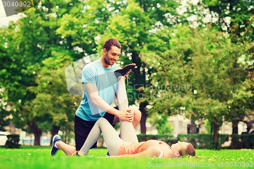 Image of smiling couple stretching outdoors