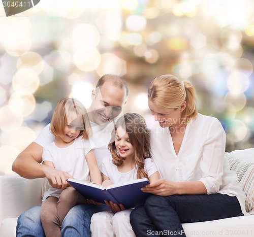 Image of happy family with book at home