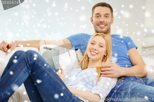 Image of smiling happy couple with tablet pc at home