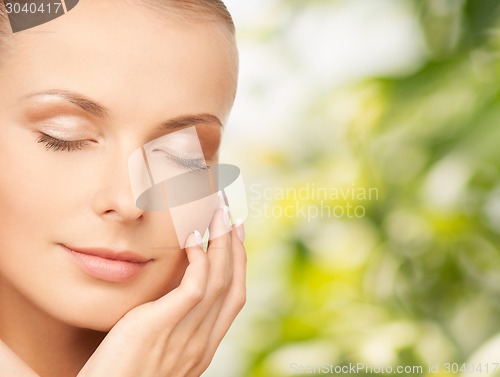 Image of beautiful young woman touching her face