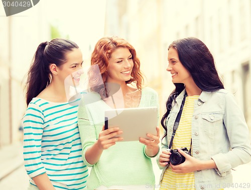Image of smiling teenage girls with tablet pc and camera