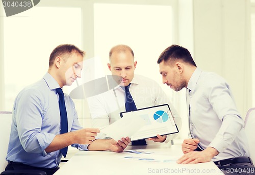 Image of serious businessmen with papers in office