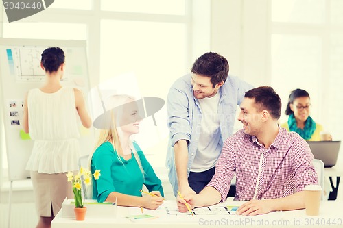 Image of smiling interior designers working in office