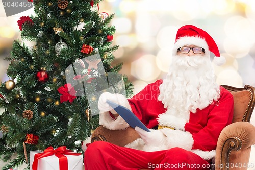 Image of man in costume of santa claus with tablet pc