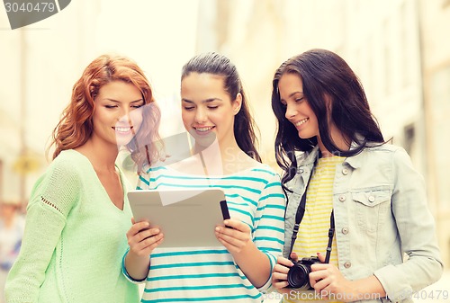 Image of smiling teenage girls with tablet pc and camera