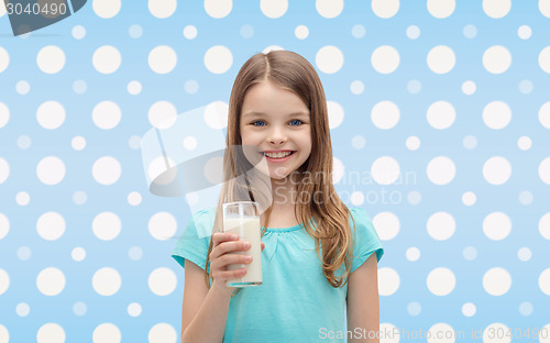 Image of smiling girl with glass of milk over polka dots