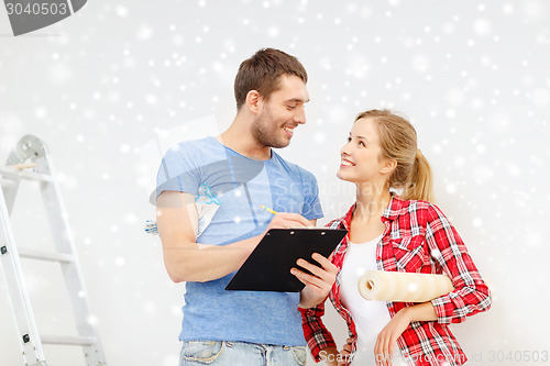 Image of smiling couple with clipboard and wallpaper roll