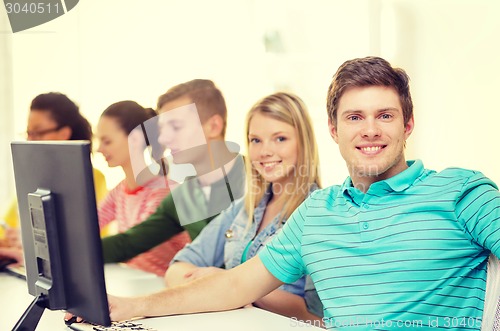 Image of male student with classmates in computer class