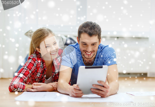 Image of smiling couple with tablet pc at home