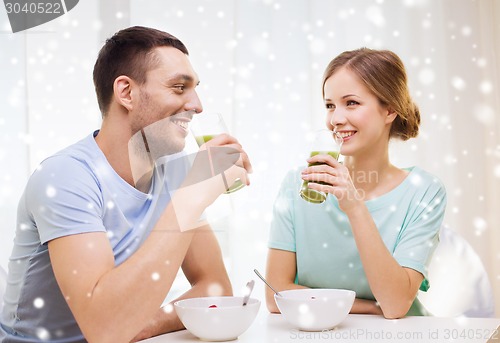 Image of smiling couple having breakfast at home