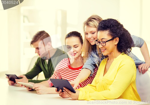 Image of smiling students looking at tablet pc at school