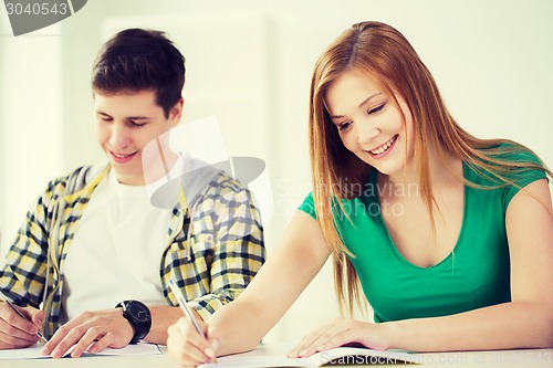 Image of smiling students with textbooks at school