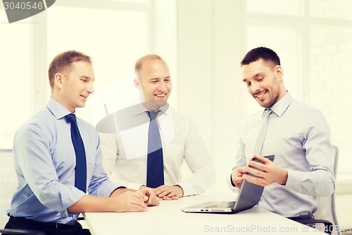 Image of business team working with laptop in office