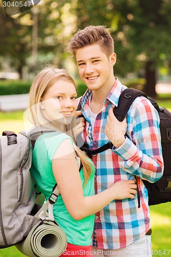 Image of smiling couple with backpacks in nature