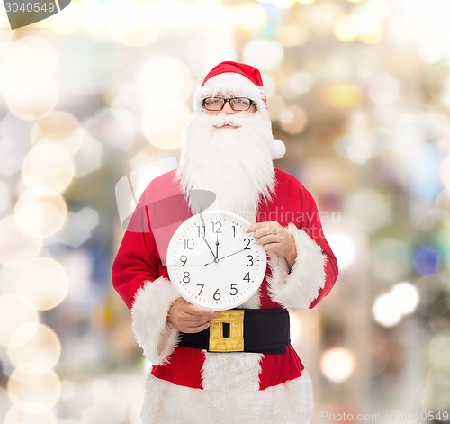 Image of man in costume of santa claus with clock