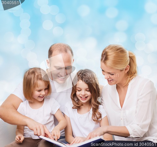 Image of happy family with book at home