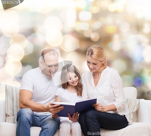 Image of happy family with book at home