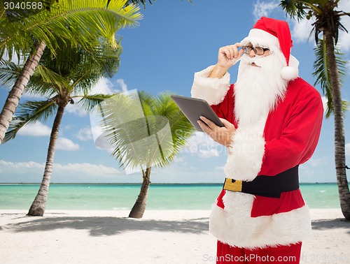 Image of man in costume of santa claus with tablet pc