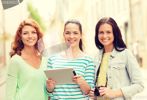 Image of smiling teenage girls with tablet pc and camera