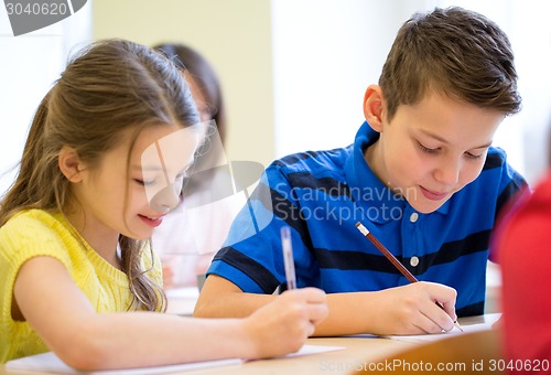 Image of group of school kids writing test in classroom