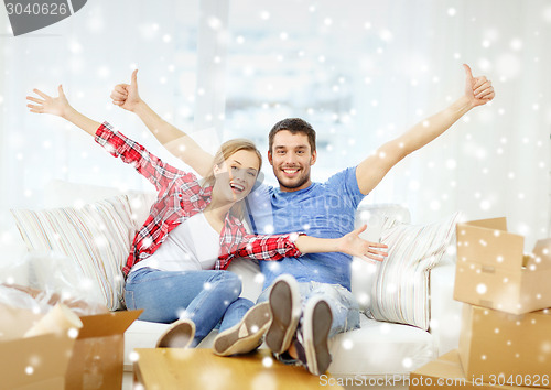 Image of smiling couple relaxing on sofa in new home