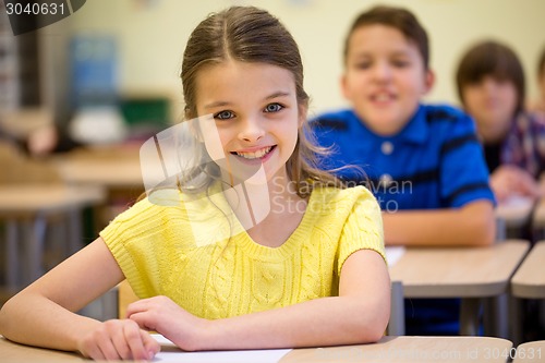 Image of group of school kids with notebooks in classroom