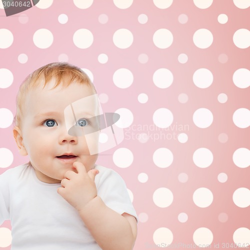 Image of smiling baby girl face over pink polka dots