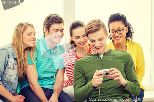 Image of smiling students with digital camera at school