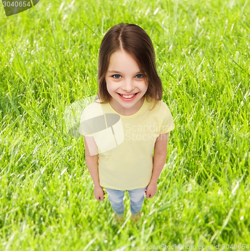 Image of smiling little girl over green grass background