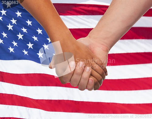 Image of close up of hands holding over american flag