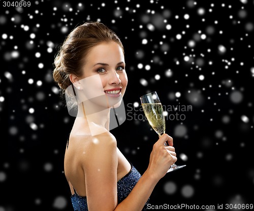 Image of smiling woman holding glass of sparkling wine