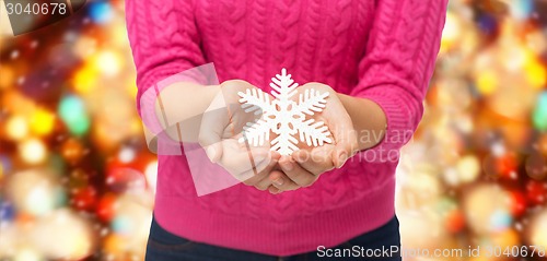 Image of close up of woman holding snowflake decoration