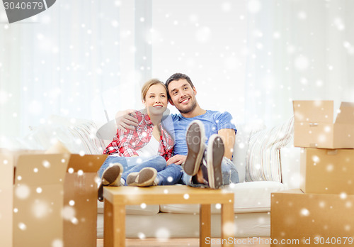 Image of smiling couple relaxing on sofa in new home