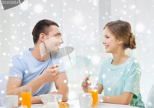 Image of smiling couple having breakfast at home